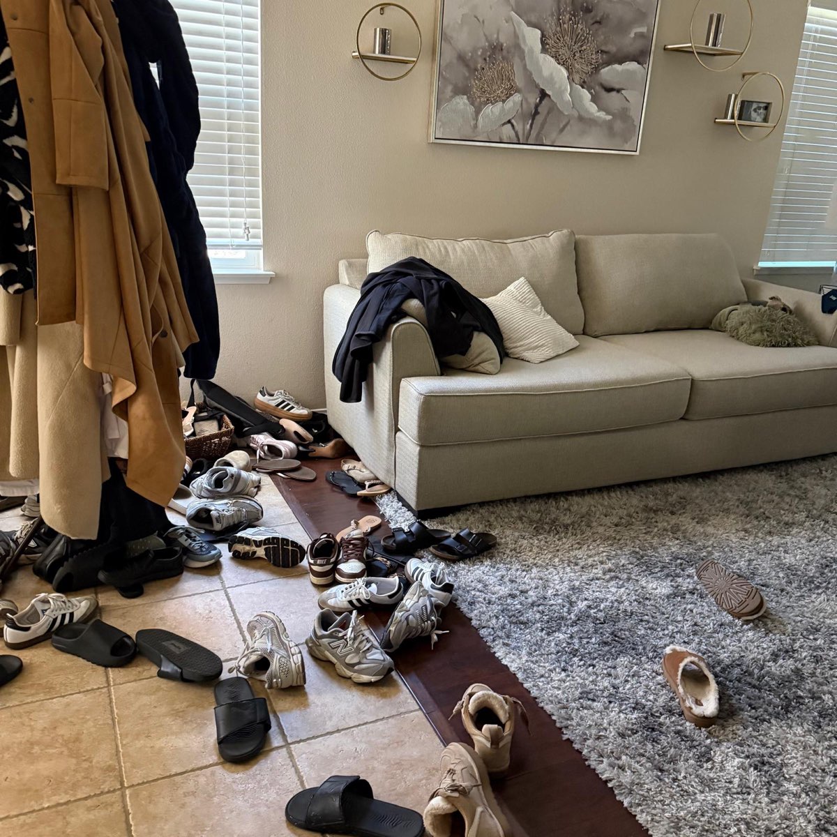 Living room before cleaning — shoes and belongings scattered across the floor
